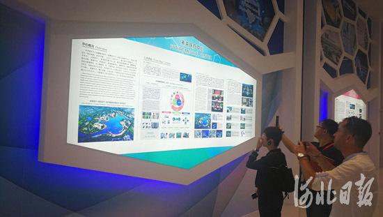 观摩团成员观看国际康养旅游中心宣传展板。