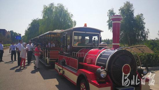 观摩团登上观光小火车,乘车游览沙雕海洋乐园。