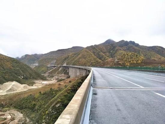 清晨,天空中的乌云压得很低,远处的青山云雾缭绕,张石高速路面整洁,道路平坦。(刘颖)