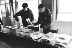 田洋(右)和学校工作人员整理捐给孩子的学习用品。