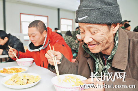 流浪人员在救助站吃上了热乎乎的饭菜。资料图
