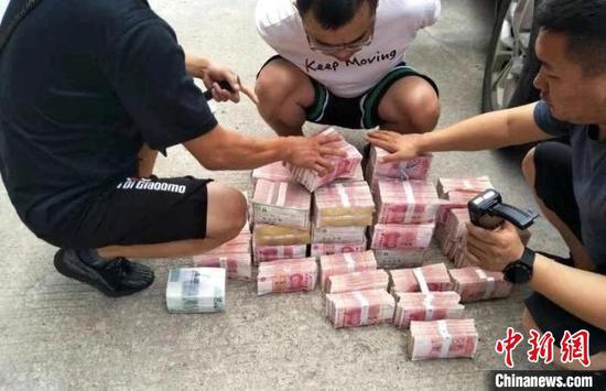 图为民警现场扣押赃款。河北省公安厅供图