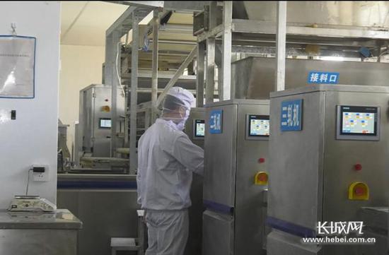 麦客食品公司员工在成型车间操作成型机。