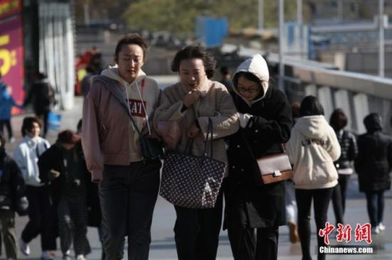 资料图：市民在寒冷天气中出行。 中新社记者 蒋启明 摄