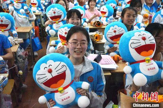 图为6月5日,河南郑州市第四中学高三学子展示收到的哆啦A梦公仔。 中新社记者 韩章云 摄