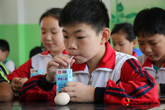 图为9月5日,河北省邯郸市广平县十里铺中心小学学生课间吃上了“免费加餐”牛奶、鸡蛋。