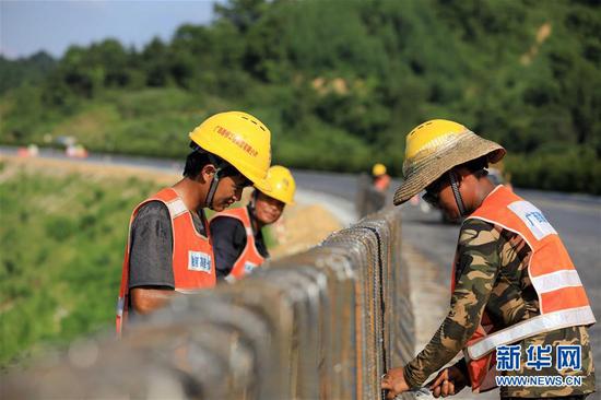 7月23日，在融河高速广西柳州市融安县潭头乡段建设工地，工人在扎制防护栏钢筋。 新华社发（谭凯兴 摄）