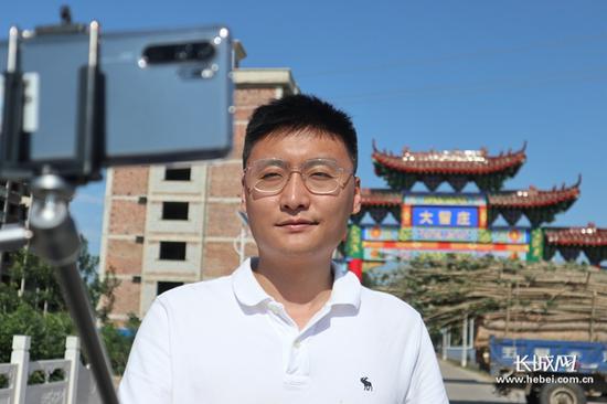 孟洋在大留庄村村口录制“第一书记出镜”,张罗着带记者去梨园看看。长城网记者 冯硕 摄