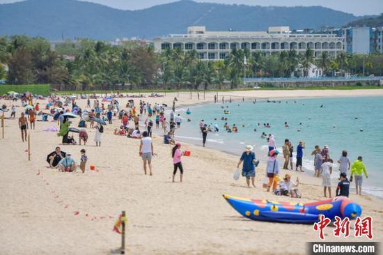 图为三亚大东海旅游景区的沙滩吸引了许多游客前来游玩,享受阳光沙滩。 骆云飞 摄