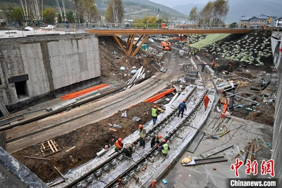 图为9月15日，建设工人正在太子城冰雪小镇有轨电车线路处施工。　翟羽佳 摄