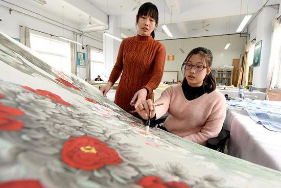 3月12日,李娜在母亲陪伴下绘制工笔画。 新华社记者朱旭东摄