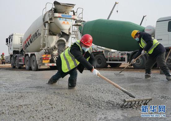 1月14日，工人在石家庄市集中隔离点建设工地硬化地面。新华社记者 杨世尧 摄