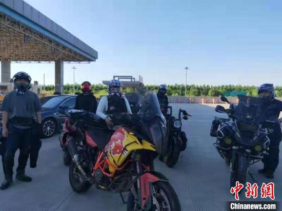 民警让5位车主将摩托车推至收费站外接受检查。 刘文杰 摄