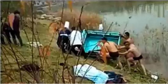 (众人合力打捞三轮车。视频截图)
