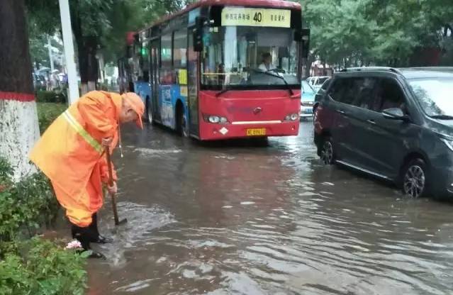 邢台环卫工冒雨清理排水管道