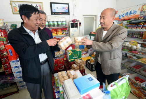 在霸州市南夹河村,乡村食品药品协管员(左)到超市检查出售的食品。(资料片)新华社记者李晓果摄