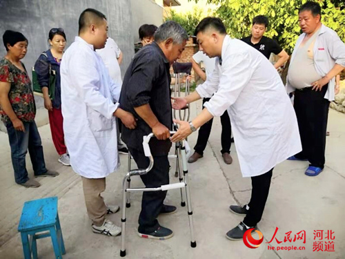 图为工作人员为残疾人适配助行器。图片来源:河北省残联
