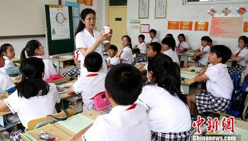 资料图:眼科医生向孩子们普及眼保健知识。中新社记者 宋敏涛 摄
