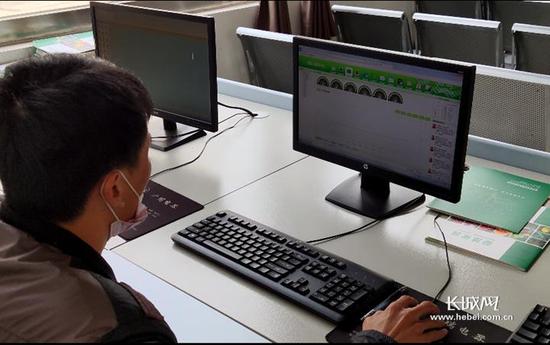 技术人员通过电脑监测农业大棚内各项数据。