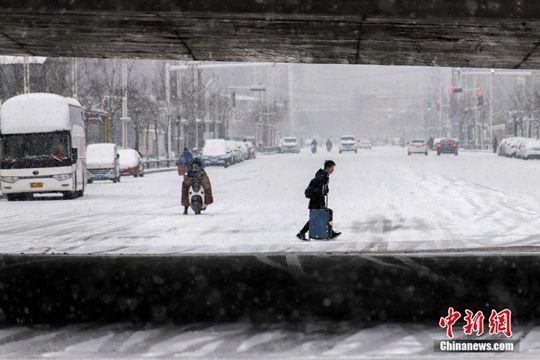 图为郑州市民冒雪出行。中新社记者 王中举 摄