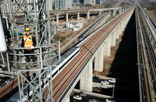 1月17日，牛军辉在郑州东站附近的一座信号塔上进行检修作业（无人机拍摄）。