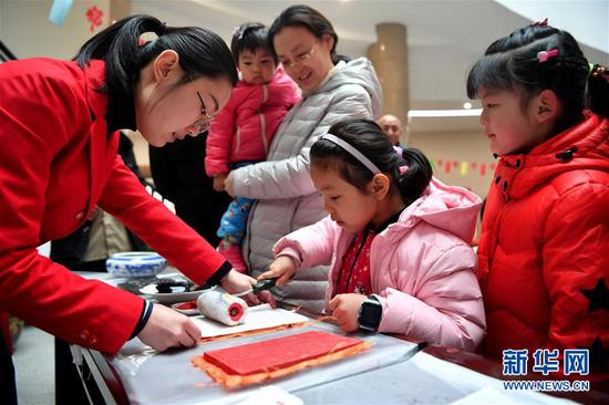 2月6日，小朋友在郑州博物馆体验制作木版年画。新华社记者 李嘉南 摄