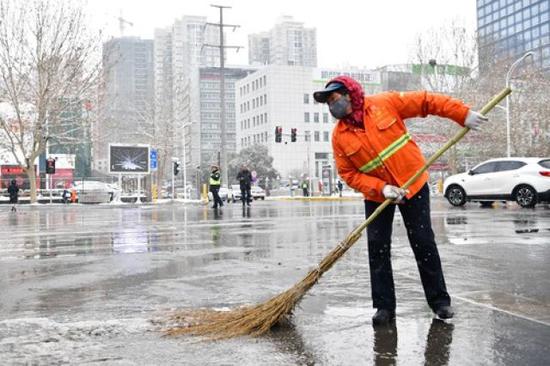 2月10日,环卫工人清除路面积雪。
