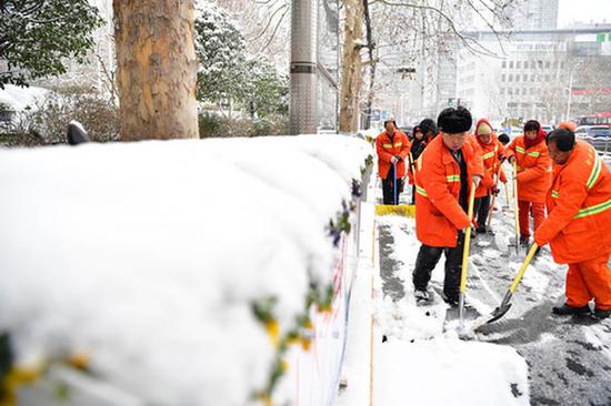2月10日,环卫工人清除路面积雪。