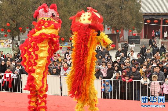 2月7日,河南许昌,人们在灞陵桥景区新春大庙会上观看舞狮表演。