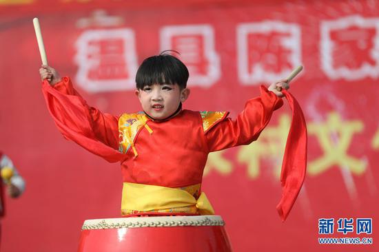 2月19日，河南省温县赵堡镇，一名小朋友在敲鼓伴奏。
