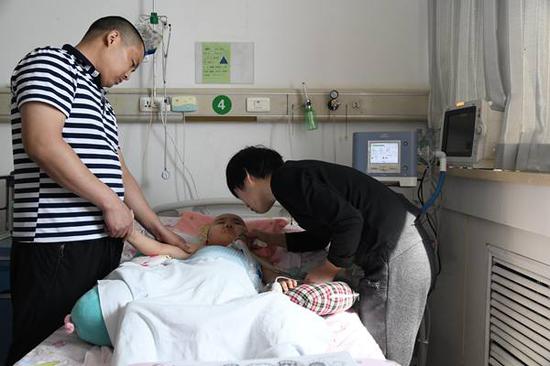 (韩焕苹和丈夫在给棠棠做按摩)