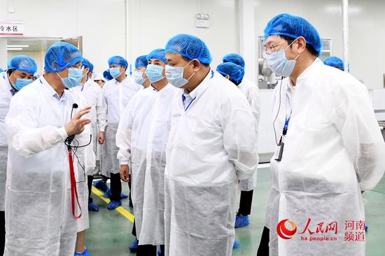 馬林青（右二）帶領(lǐng)參會人員觀摩6S標準化管理成果