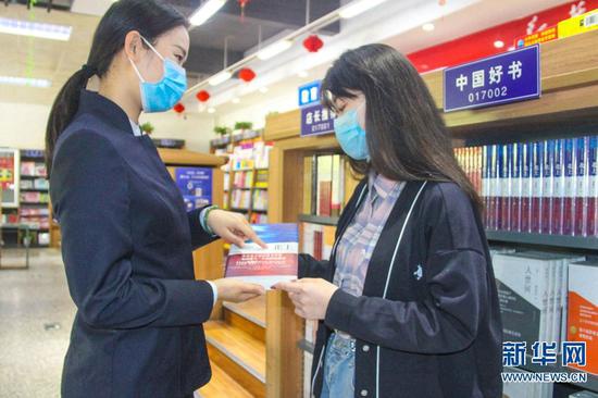 　4月23日，南阳市新华书店工作人员向顾客推荐好书。新华网发（高嵩 摄）