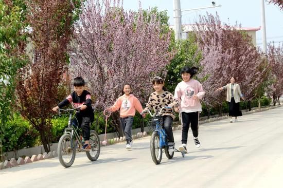村民在新修建的道路上游玩,脸上洋溢着幸福的笑容
