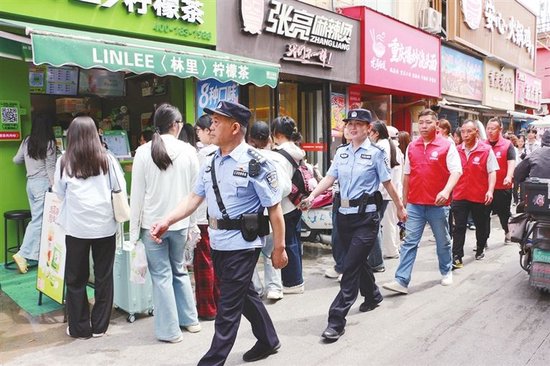 安阳市公安局高新技术产业开发区分局商颂大街派出所民警联合网格员在后营商业街开展徒步巡防。苗茹 摄