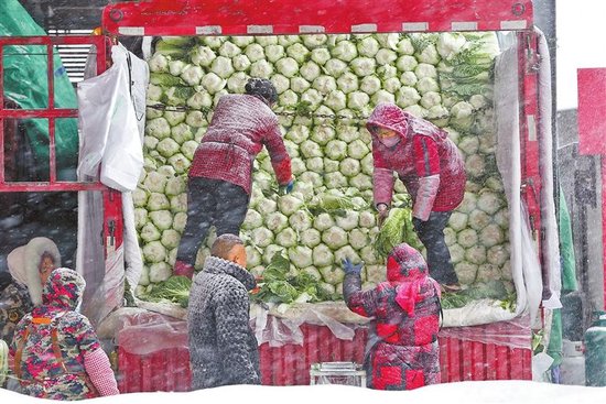 1月19日，在河南万邦国际农产品物流城，工作人员在搬运蔬菜。面对恶劣天气，市场确保货源充足、种类齐全，有效保障降雪期间城乡居民的“菜篮子”需求。 本报全媒体记者 王铮 摄