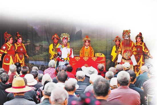 5月23日，村民们在安阳市内黄县马上乡北菜村文化广场观看豫剧。 刘肖坤 摄