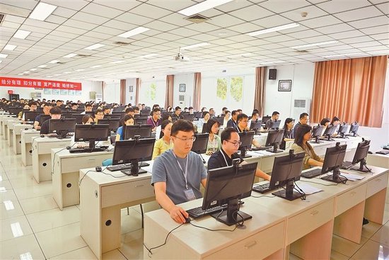 评卷机房内，评卷教师们正在电脑前认真评阅。 本报全媒体记者 樊雪婧 摄