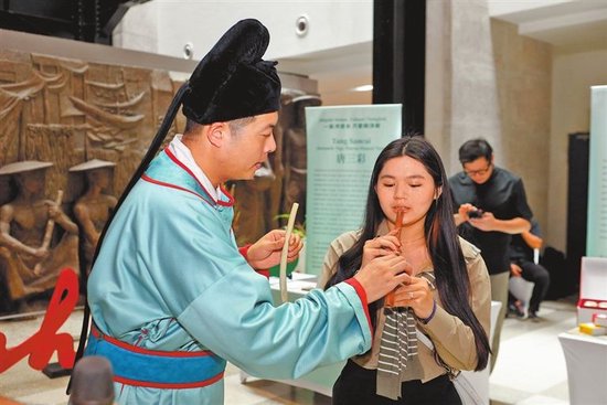 图② 当地市民体验吹奏贾湖骨笛。