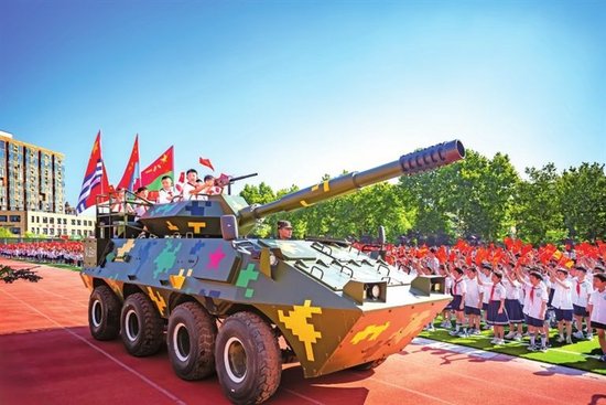 漯河市太行山路小学开学第一课，孩子们体验仿真战车，挥舞国旗，沉浸式感受国防力量的强大。赵书杰 摄影