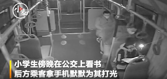 映象网|小学生公交上看书，后方乘客默默为其照明