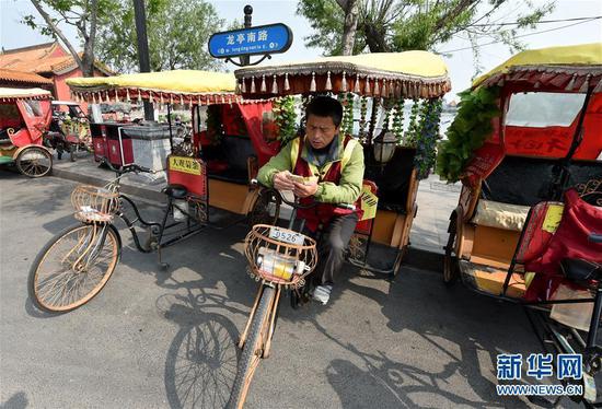 许世杰在开封市龙亭景区附近“趴活”(4月26日摄)。