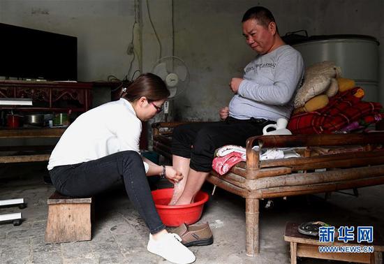 5月30日，韓紅曉為丈夫賈洪濤洗腳。新華社記者 李安 攝