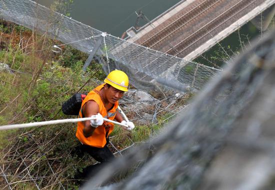 8月9日，抢险人员从侯月铁路柏枝隧道上方山顶垂降，准备进行碎石作业。