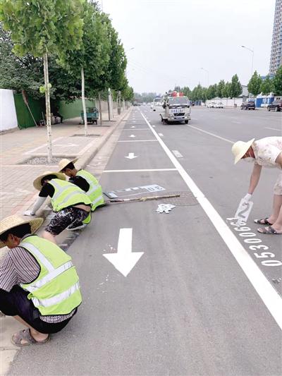 工作人员在惠济区英才街划停车位