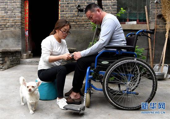 5月30日，韩红晓为丈夫贾洪涛修剪指甲。 新华社记者 李安 摄