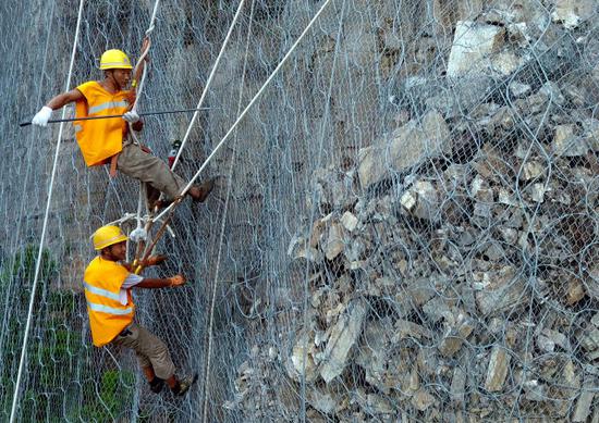 8月9日，抢险人员在侯月铁路柏枝隧道上方悬崖进行碎石作业（无人机拍摄）。