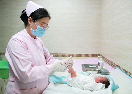 省妇幼保健院医护人员正在为新生儿采足底血，进行新生儿疾病筛查。 何剑烁 摄