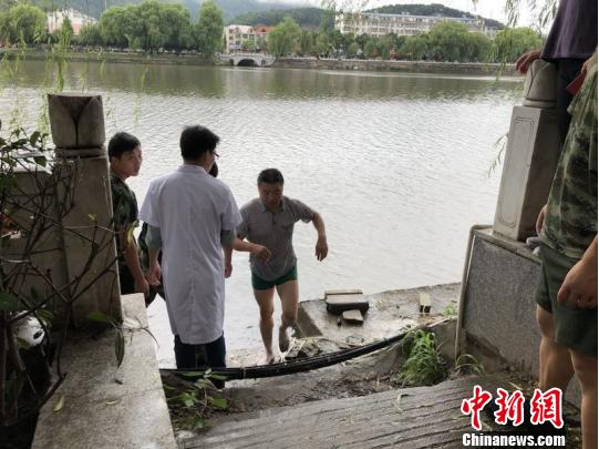 图为金诚老师救人后上岸离开。