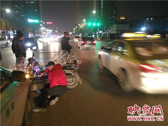 车上挂十几个气球闯红灯 男子违规行驶引发交通事故